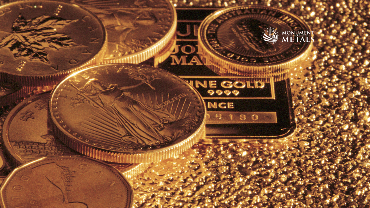 Gold bullion coins and a .9999 fine gold bar arranged on gold granules, featuring recognizable designs like the Canadian Maple Leaf and American Gold Eagle, highlighting gold investment and precious metals value with Monument Metals branding.