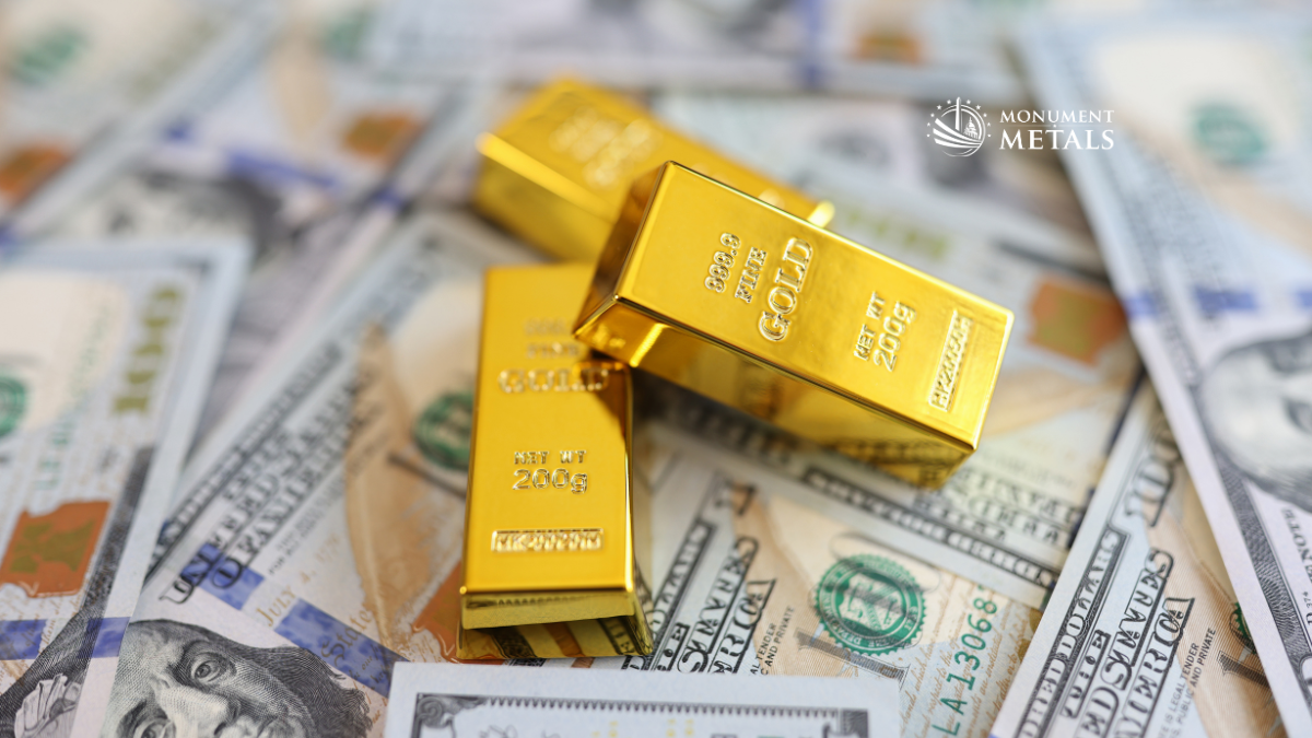 Gold bars stacked on U.S. dollar bills illustrating the relationship between the U.S. dollar and precious metals prices.