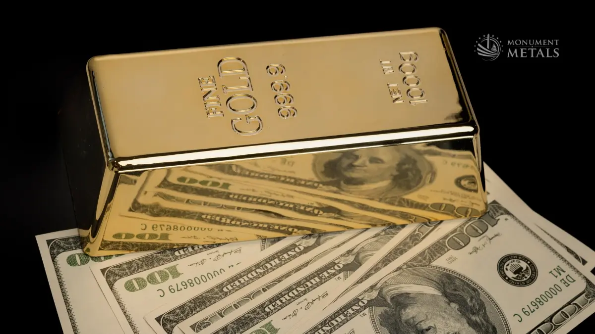 One-kilogram .9999 fine gold bar displayed over U.S. hundred-dollar bills against a black background.